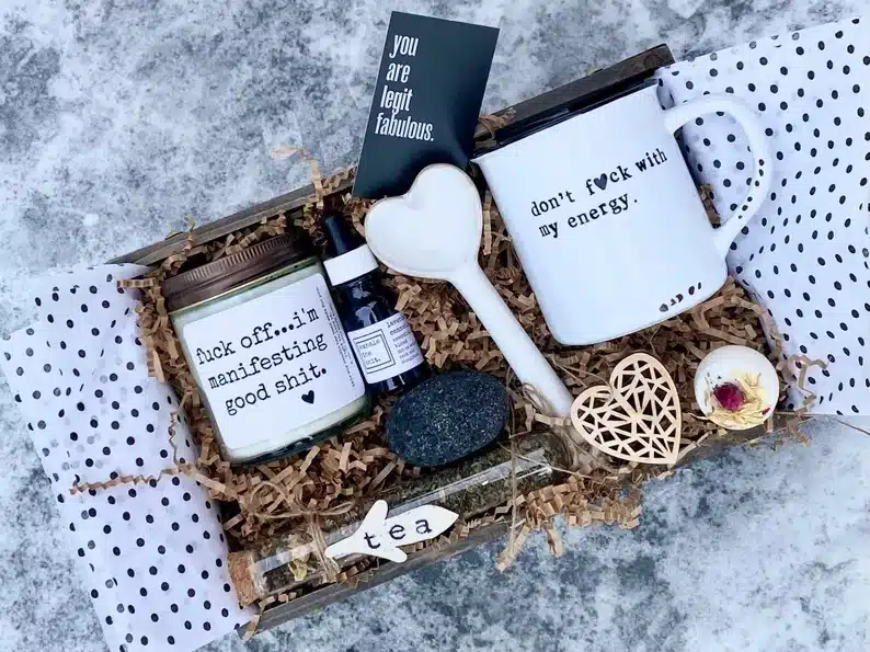 Unique gift basket with a mug, heart shaped spoon, tea, candle, and various other spa like items. 
