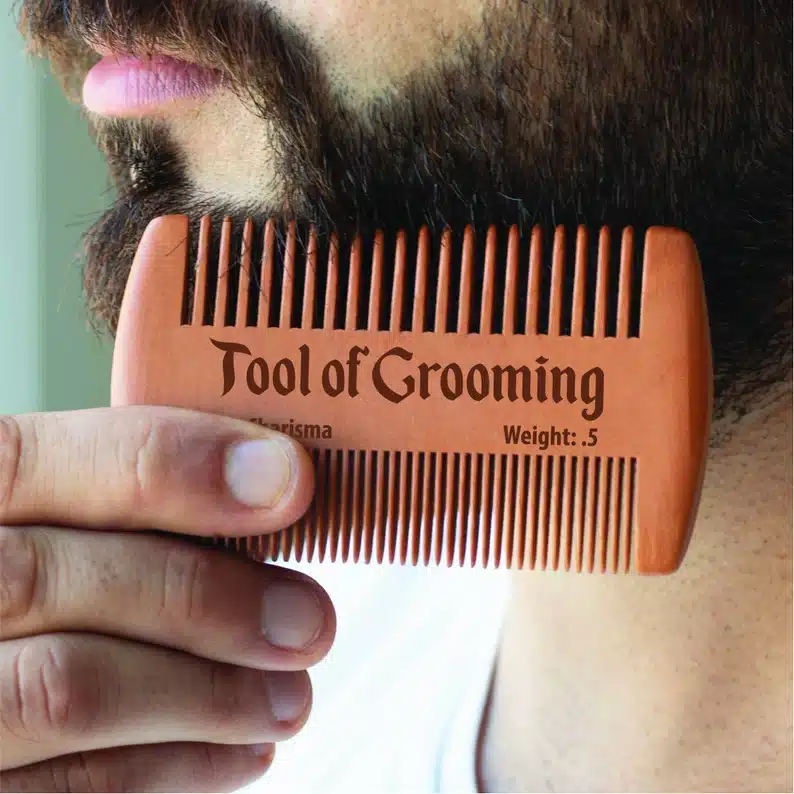 Close up of a mans beard being groomed with a beard comb. 