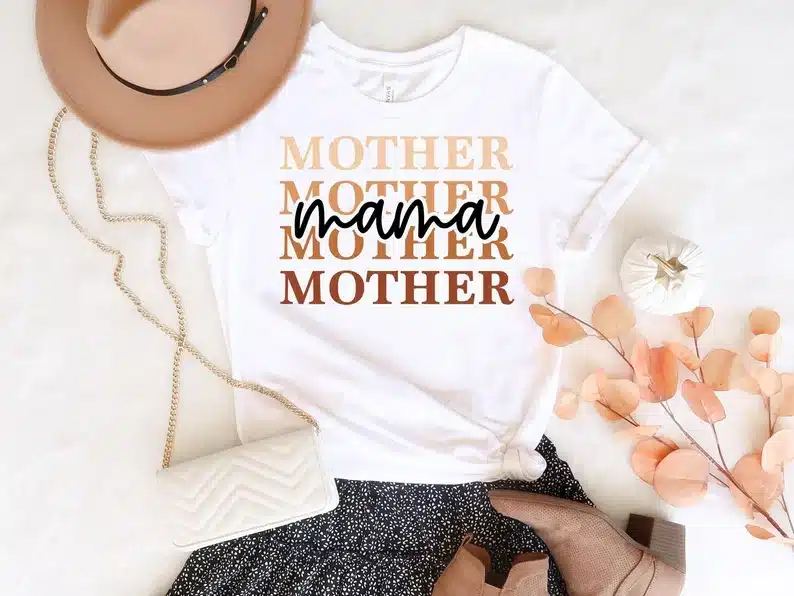 White t-shirt with mother mother mother mother in various brown shaded font with NANA in black font overtop. 
