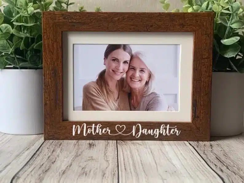 Wooden frame with white font below that says Mother hearts daughter. 