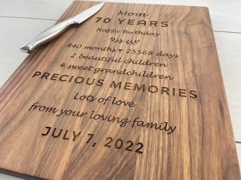 Personalized cutting board, dark wood board engraved with a poem. with a silver knife on top. 