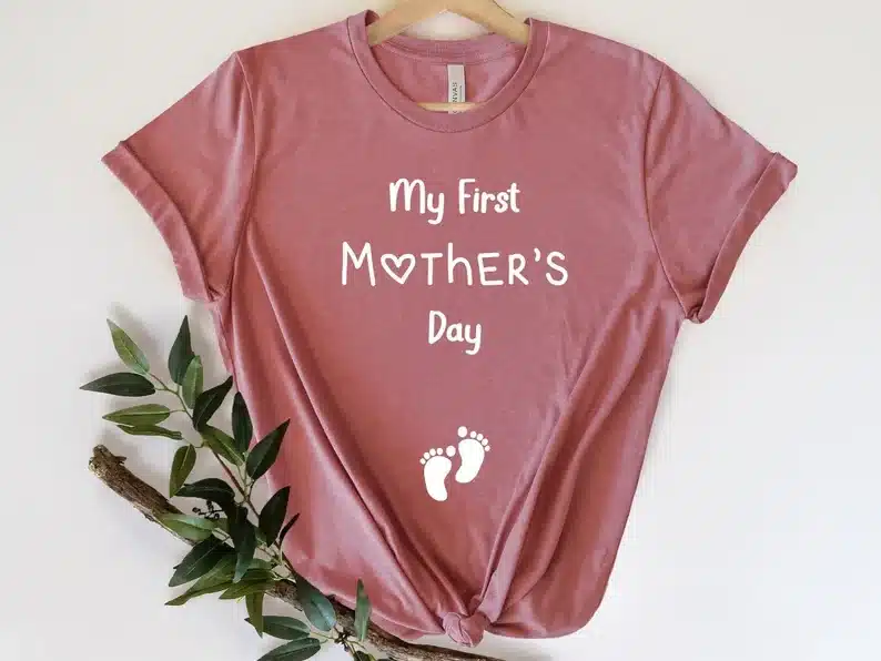 Mother's Day Gifts For Expecting Mothers: Dusty rose pink t-shirt with white font that says "my first mother's day" with two tiny white footprints below. 