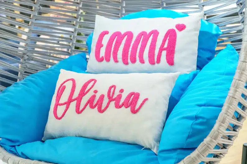 Gift Ideas for a Teenage Girl's Best Friend: Wicker chair with blue pillow cushions and two rectangle white pillows with pink font in girls names. 
