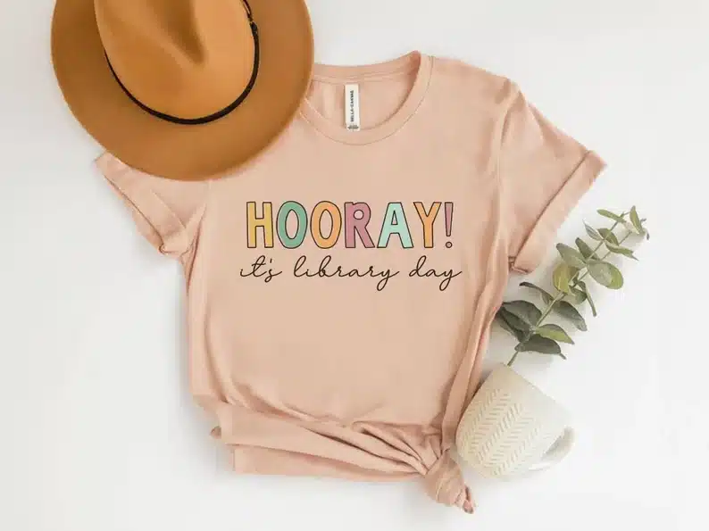 National Library Workers Day Gift shirt gift ideas. light pink shirt that says HOORAY! It's library day. 