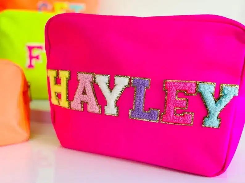 Hot pink neon cosmetic bag with colorful Hayley on it. 