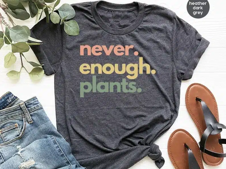 Grey t-shirt with the font never enough plants on it. 