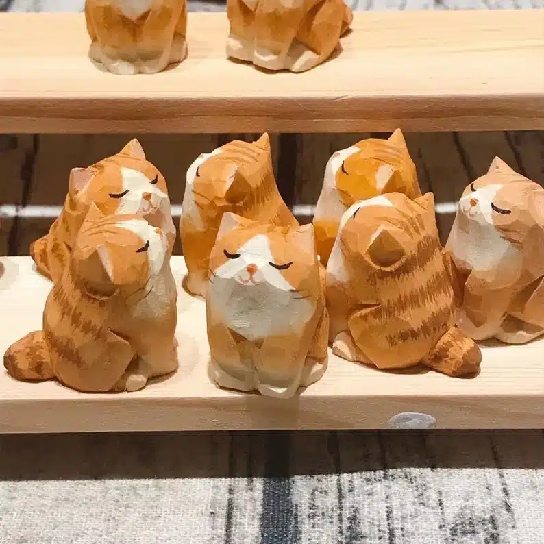 Seven carved cat statues shown. 