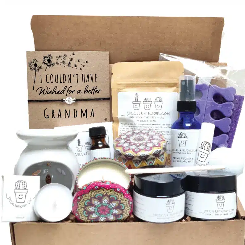 Cardboard bow opened to show a gift set of lotions, bracelet, candles, and more. 
