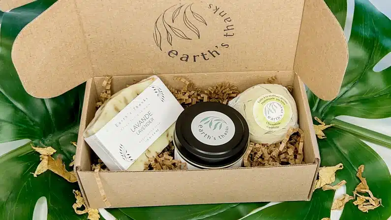 Cardboard box opened to show earth's thanks basics bath set with soap, lotion and more. 