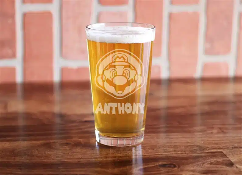 Clear beer pint glass etched with Mario face and custom name below. 