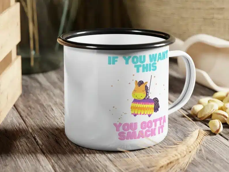 Cinco de Mayo Party Favors: White coffee mug with a black rim that says If you want this you gotta smack it with a horse piñata on it. 