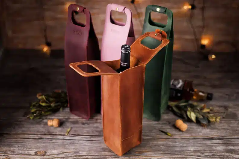 Four personalized wine totes, wine, pink, green, and brown show. Brown bag open showing a bottle of wine in it. 