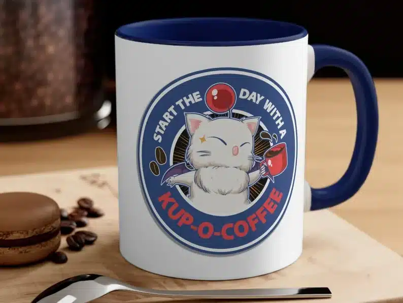 White coffee mug with navy blue inside and handle with moogle cat on it. 
