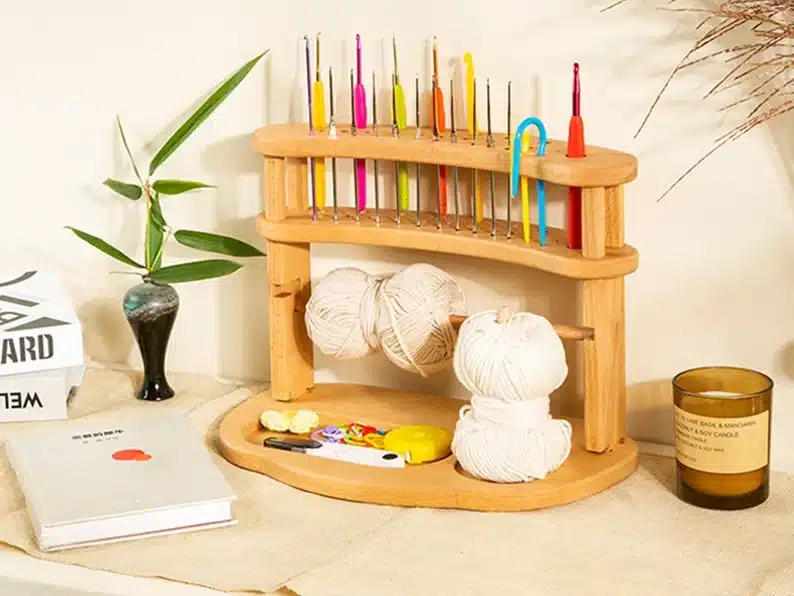Wooden crochet hook organizer, top part to hold various needles and bottom to hold yarn. 