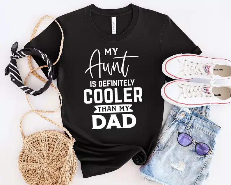 Black t-shirt with white font that says "my aunt is definitely cooler than my dad". 