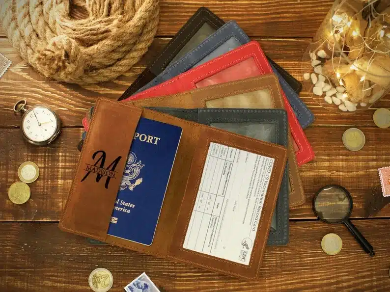 Six leather passport cases, brown, black, lighter brown, red, blue, and black shown. 