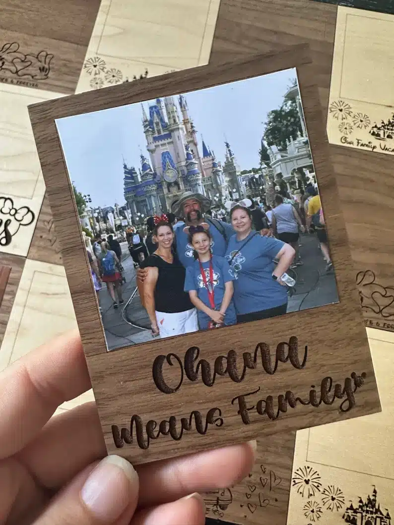 Mother’s Day Gifts for Sisters: wooden frame engraved that says Ohana means family and a picture of a family in front of the castle at Disney world. 