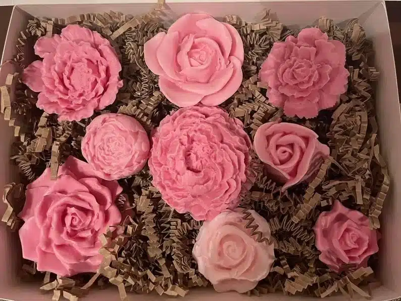 A box with a bunch of pink peony flower shaped décor soap. 