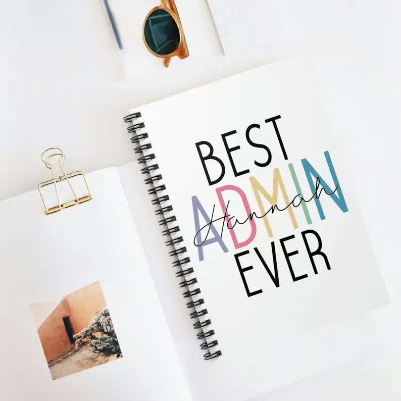 Administrative Professionals Day Gifts: White notebook with black spiral with the words "Best admin ever" on the cover. 