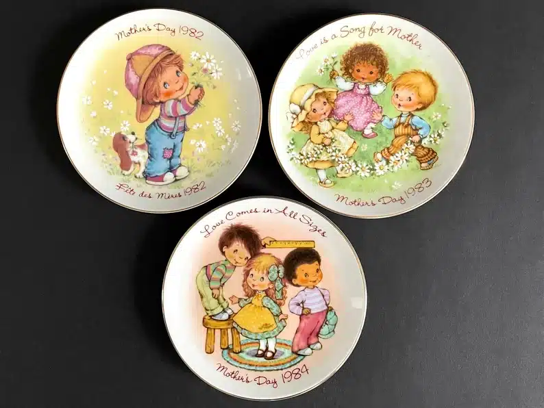Three round white vintage mother's day plates with cartoon little kits and sayings on them. 