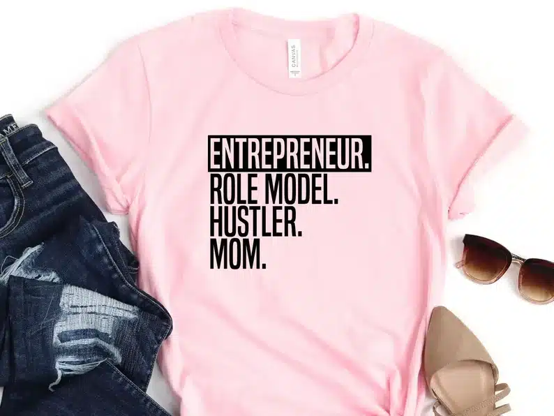 Light pink t-shirt with black font that says "entrepreneur. Role model. Hustler. mom."