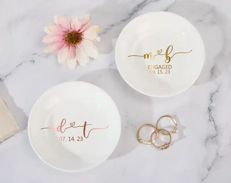 Two round white dishes with gold font that lists the wedding date on it. 