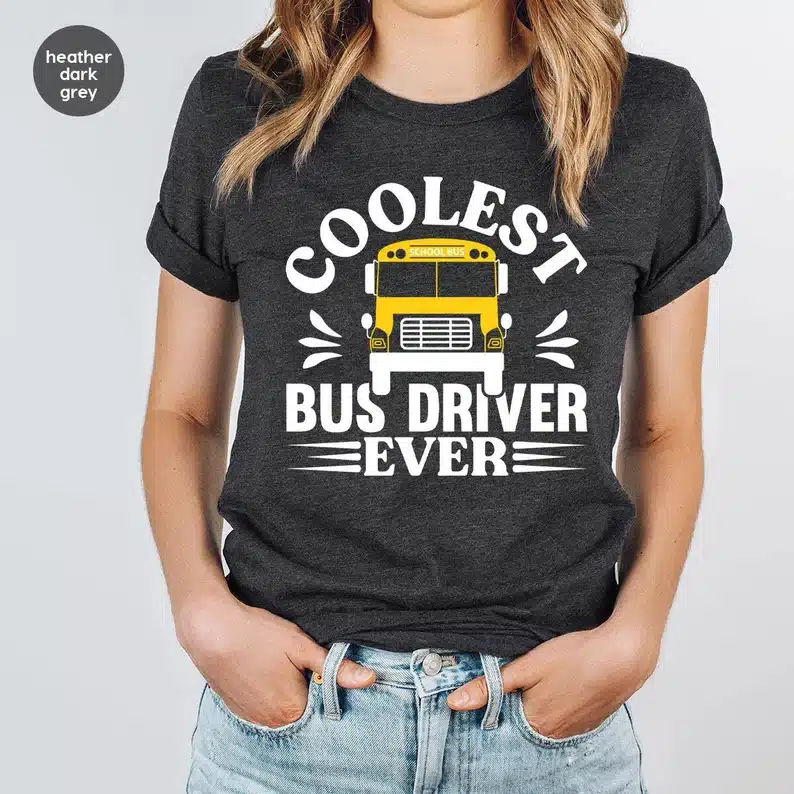 Great Gift Ideas For School Bus Drivers: CLose up of woman wearing a dark grey t-shirt with white font that says coolest bus driver ever