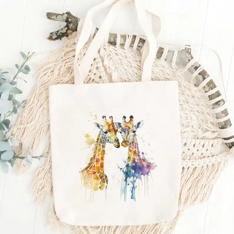White tote bag with two water colored giraffes on it. 