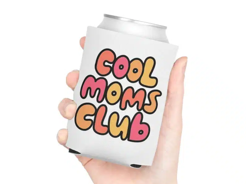 Close up of hand holding a can with a white koozie on it that says 