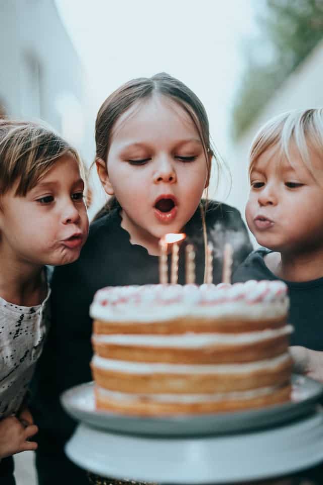 Kids blowing out candles at a party