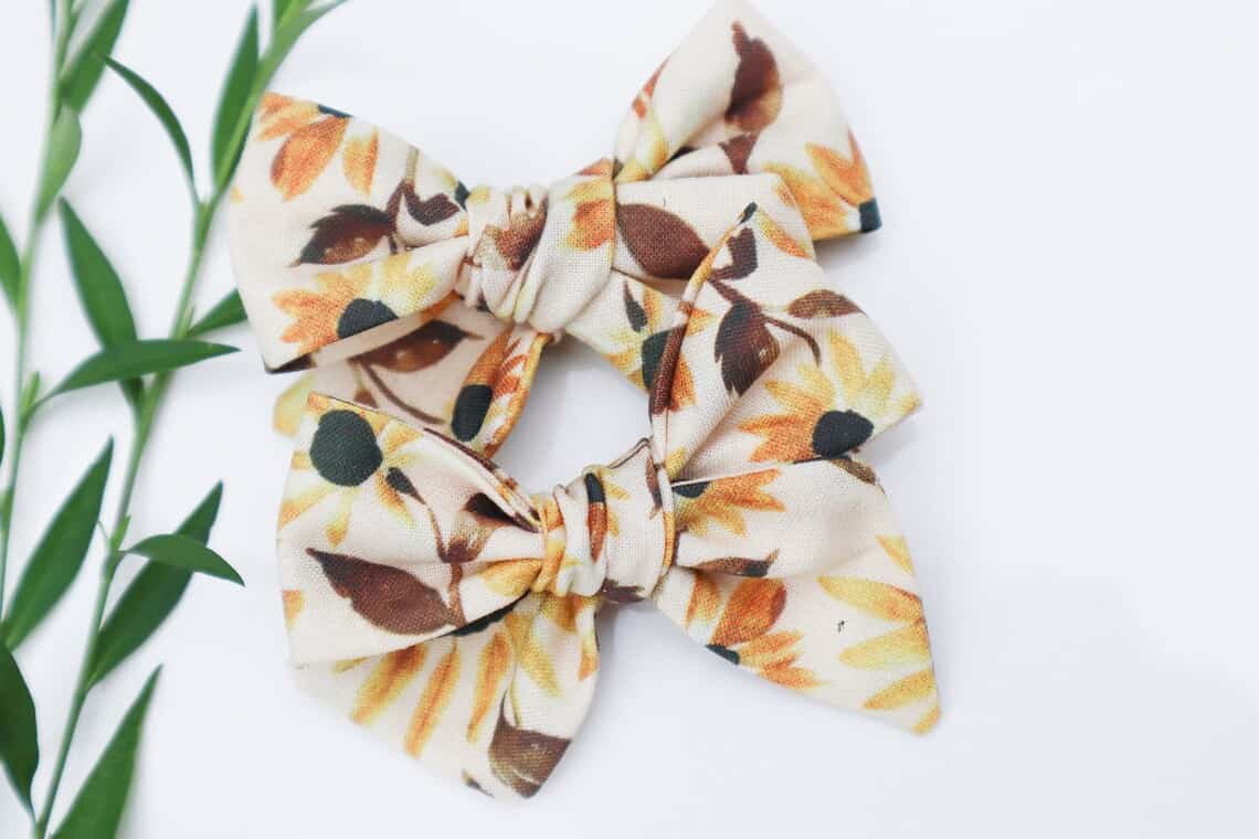 Two tan bows with sunflowers on them. 