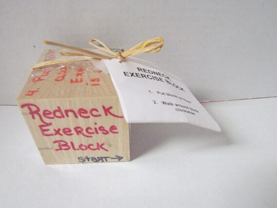 Wooden block with red font that says Redneck exercise block. 