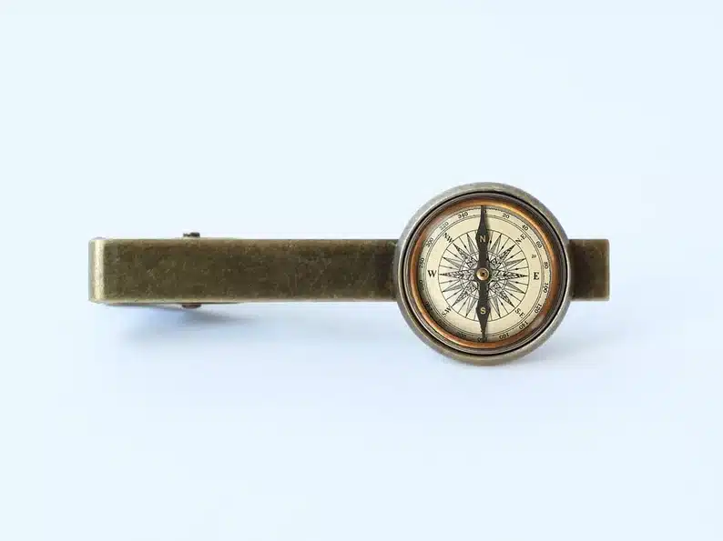 Tie clip with a round compass on it. 