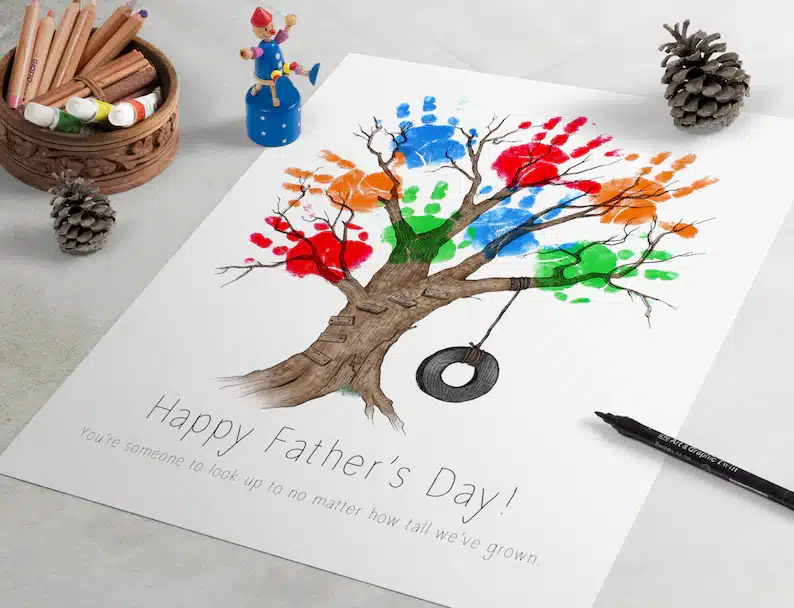 White paper with a drawing of a tree on it with many colored handprints all over it. 