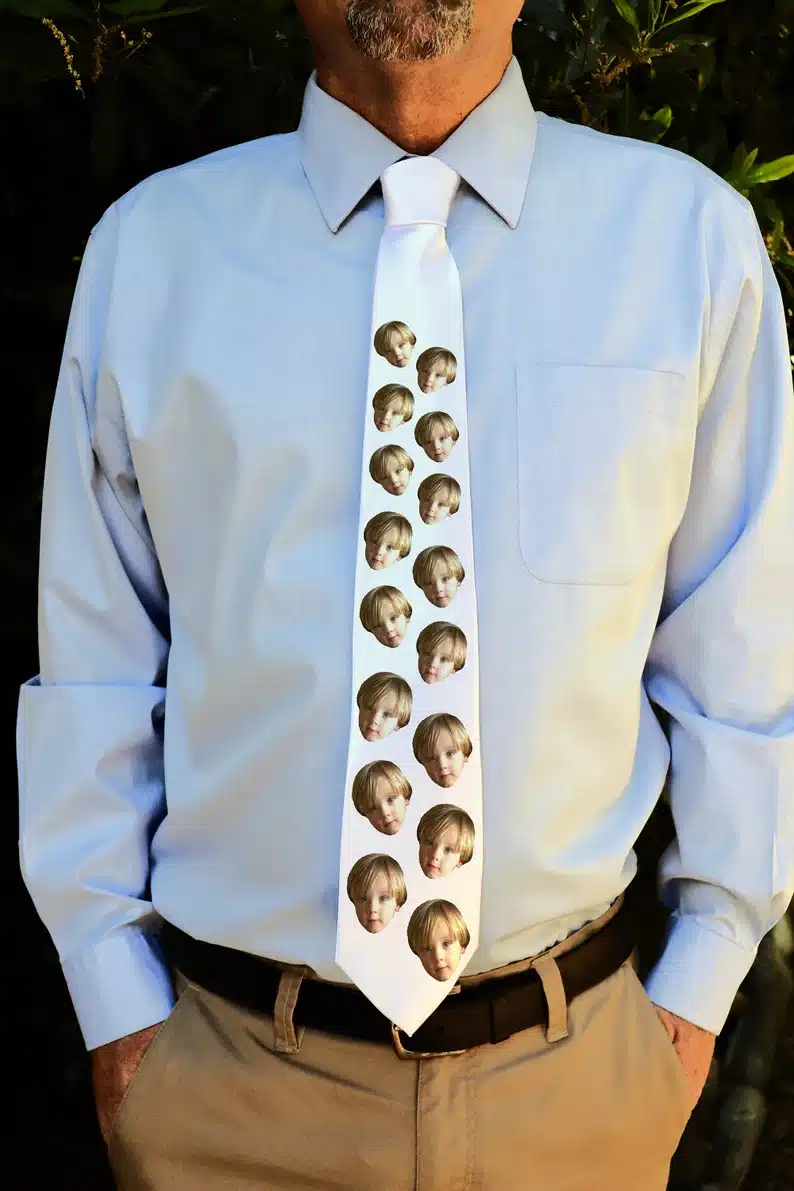 Funny Gift Ideas For Funny Father's Day 
 - Close up of man wearing a blue dress shirt with a white tie with a Childs face all over it