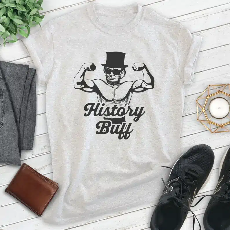 Light grey t-shirt with Abraham Lincoln showing off his muscles that says History Buff. 