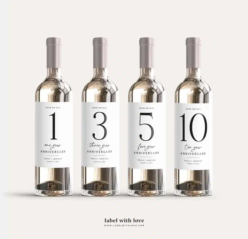 Four bottles of wine shown each with a custom milestone label on it. 