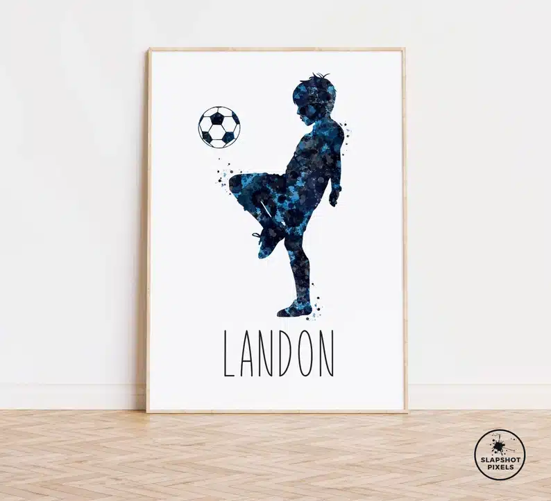 White print with a silhouette of a young boy kicking a soccer ball with the name Landon below. 
