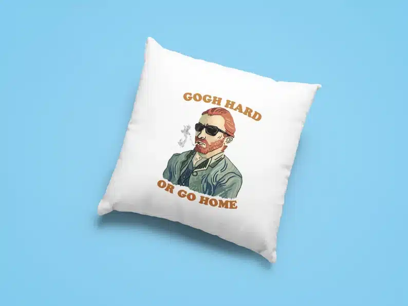 Light blue background with a square white pillow with Van Gogh wearing sunglasses with brown font that says Gogh Hard or go home. 