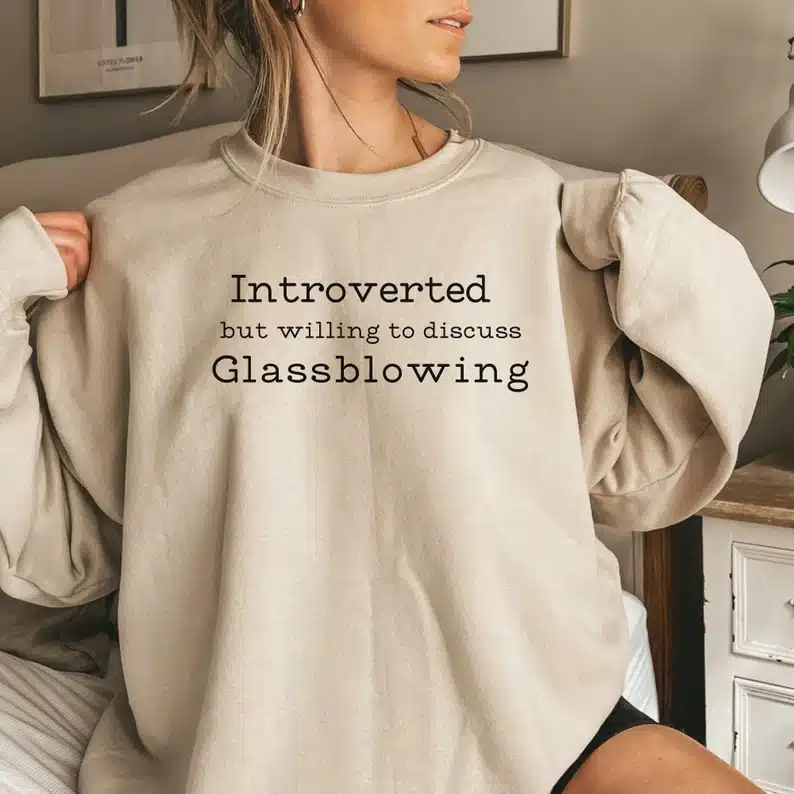 Gifts for a Glassblower - Woman wearing a tan colored long sleeve sweatshirt thatsays "Introverter ut willing to discuss glassblowing" 