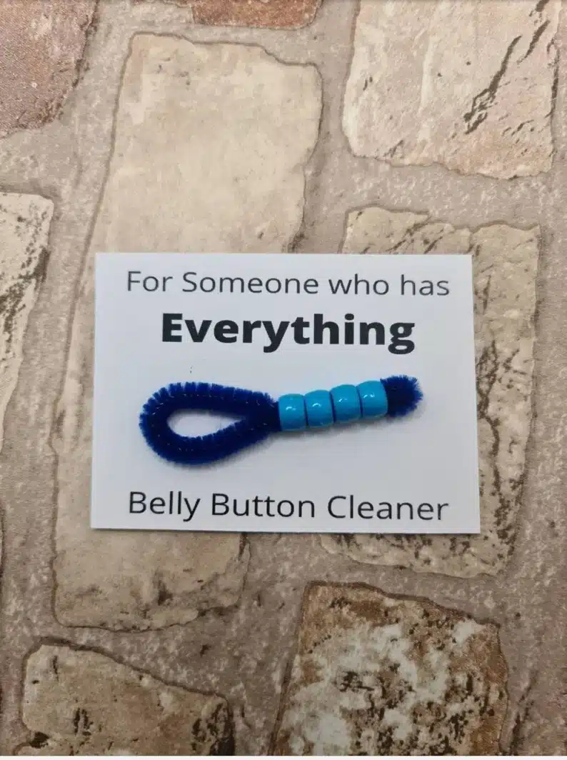 Funny Gift Ideas For Funny Father's Day - White paper that says for someone who has everything - belly button cleaner. With a pipe cleaner with beads. 