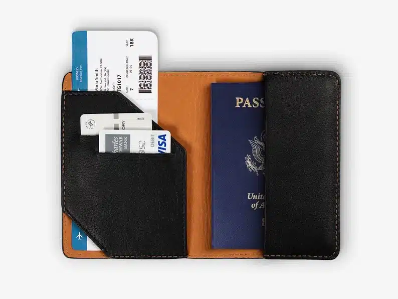 Black leather passport case with a blue passport in it, and a few credit cards. 