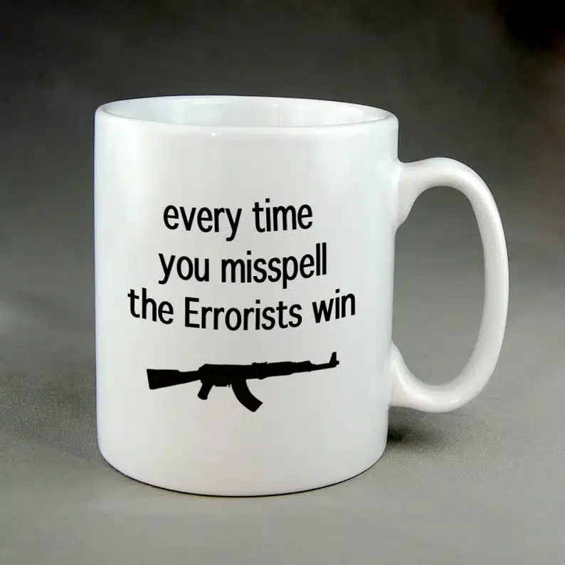 White coffee mug with black font that says Every time you misspell the errorists win with a machine gun. 