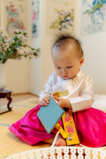 Korean baby opening a traditional first birthday gift
