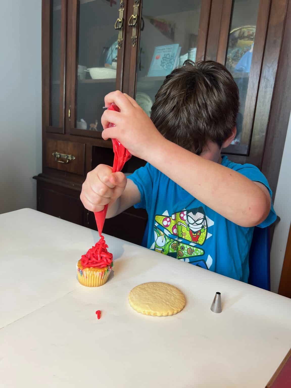 Kid decorating a cupcake at a cupcake decorating party