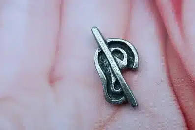 Lapel pin of an ear with a line over it