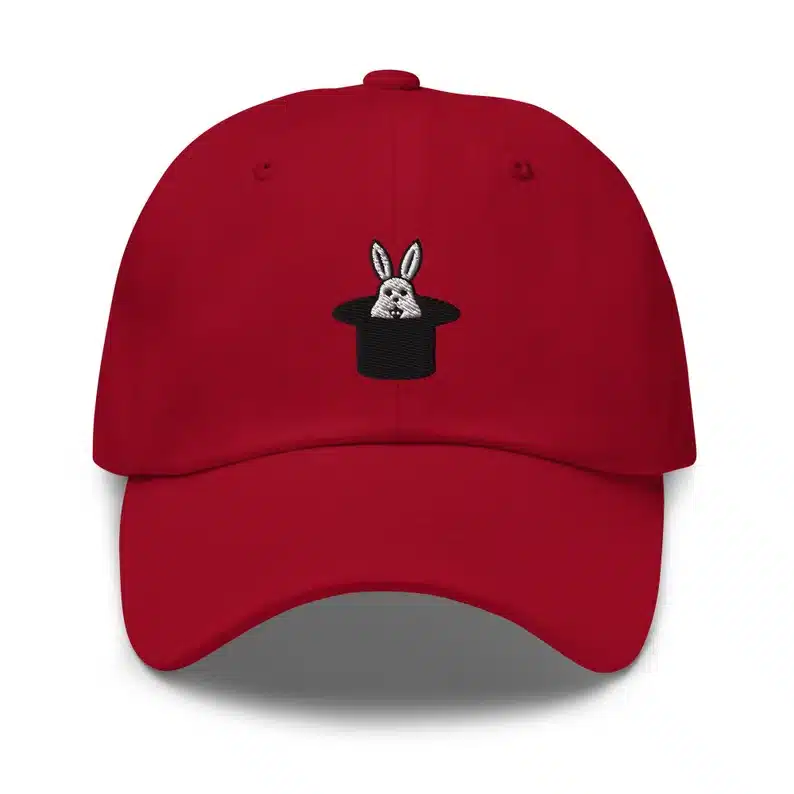 Burgundy baseball hat with a black hat stitched on with a little white bunny sticking out 