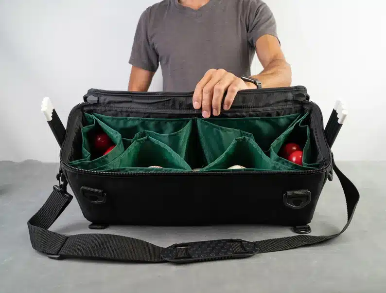 Black bag with green insert with many compartments. 