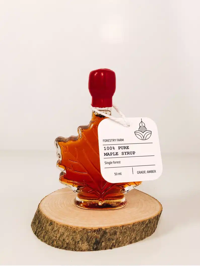 The Most Delicious Edible Wedding Favors - A small glass jar shaped like a maple leaf full of syrup. 