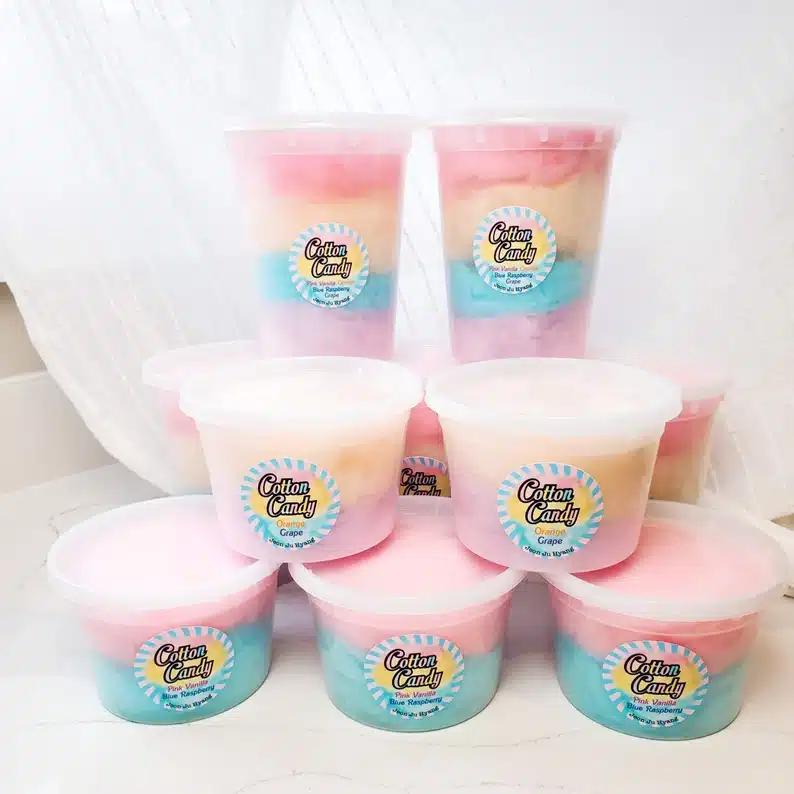 Various tubs of cotton candy both pink and blue. Some pink and yellow. 